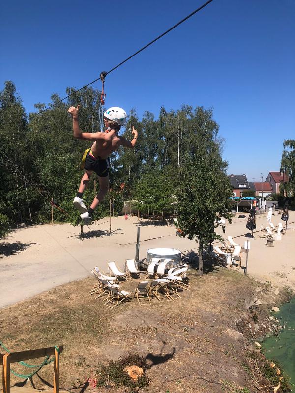 Een jongen aan het slacklinen op sportkamp in Waregem