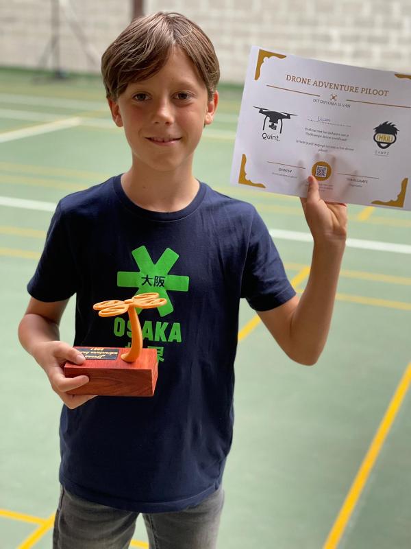 Jongen houd een certificaat omhoog tijdens een game kamp