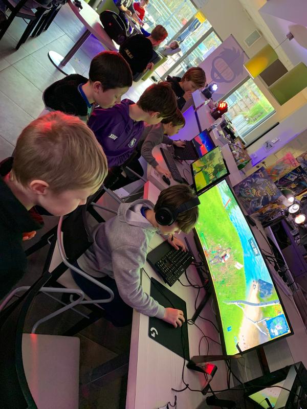 Grote gameschermen en kinderen tijdens game kamp