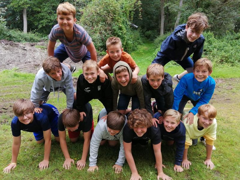 des jeunes font une pyramide dehors pendant une colonie informatique 