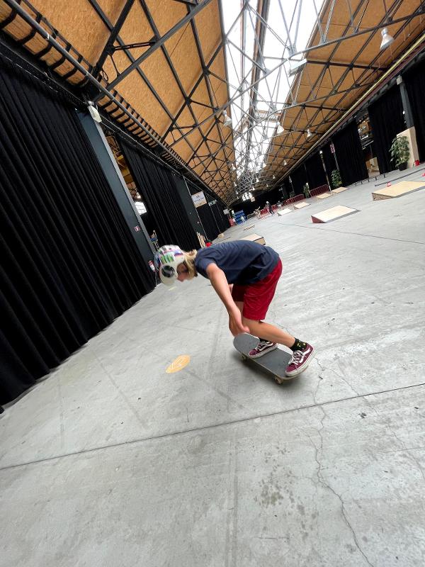 actiefoto van jongen op skateboard in skatehal op skatekamp in schoten