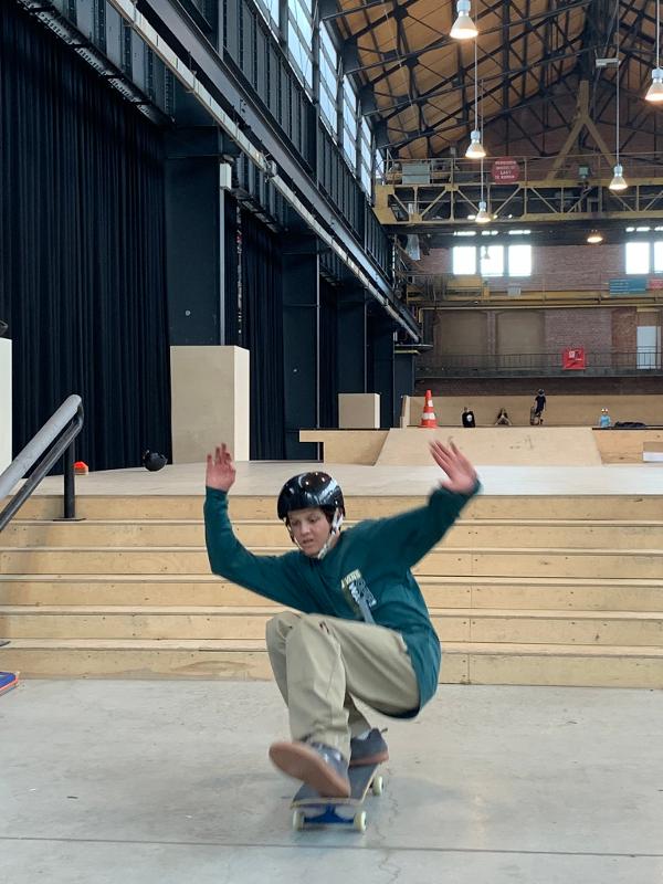 jongen doet een skatetruc in de skatehal op skatekamp in schoten