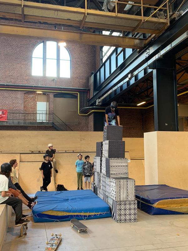 jongen klimt op trap met valkussen ernaast tijdens skate kamp in schoten