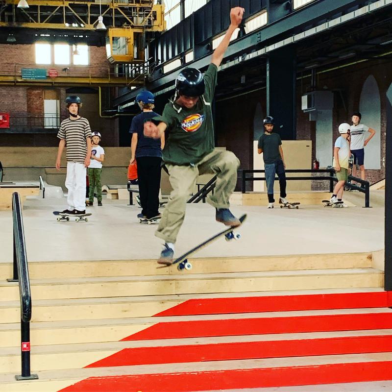 jongen doet skatetruc in de skatehal tijdens skate kamp in schoten