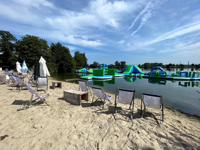 Plage avec transats et installations gonflables sur l'eau en colonie nautique