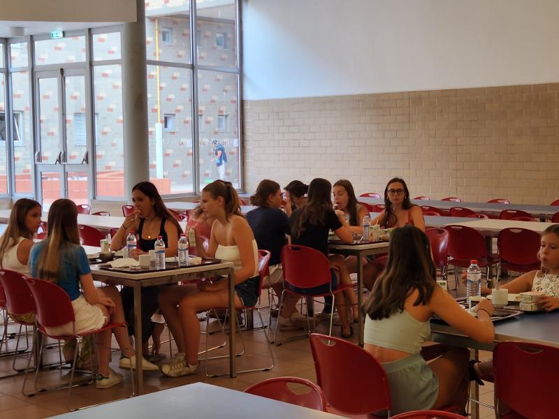 Een groep deelnemers aan de taalcursus Portugal zitten te lunchen in het schoolgebouw