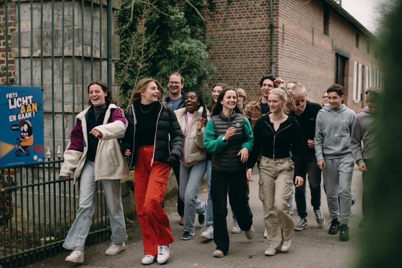Deelnemers van een jongerenvakantie België lopen en lachen samen