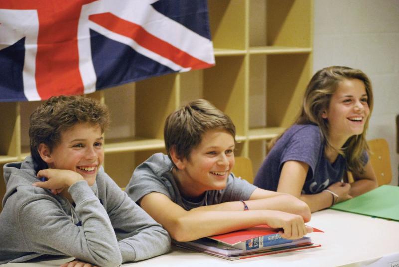 Jongens en een meisje lachend in klaslokaal op taalreis Engels
