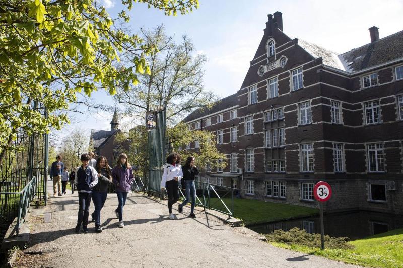 Het gebouw van een taalkamp België, deelnemers lopen over een bruggetje voorbij