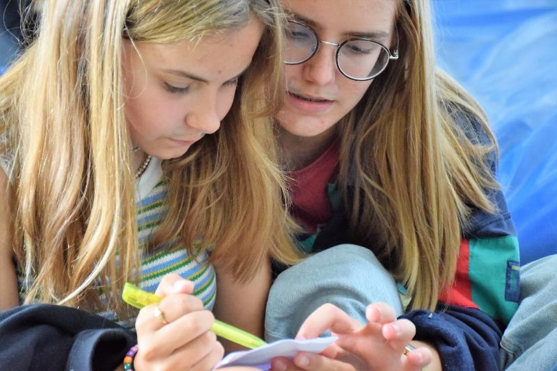 filles qui écrivent sur un papier en colonie de vacances