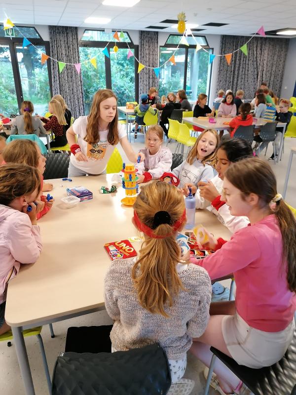 kinderen spelen uno binnen in de zaal op muziekkamp 