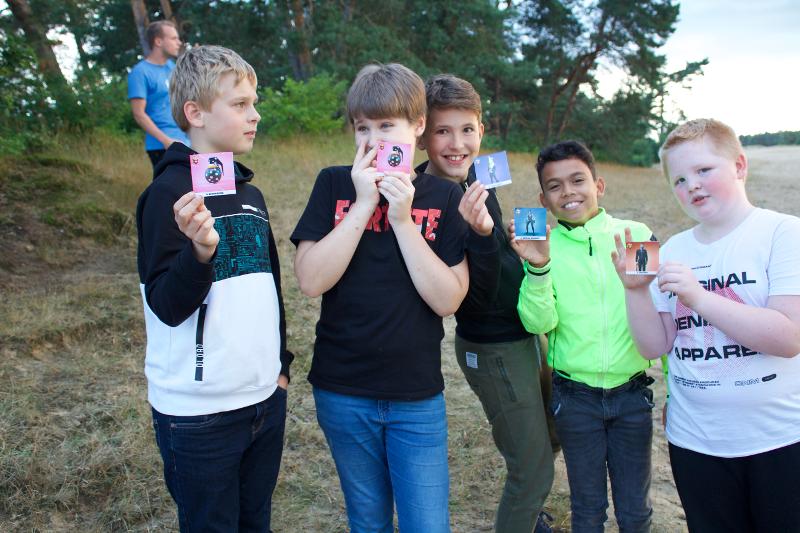Jongens zijn met kaarten aan het spelen op fortnite kamp