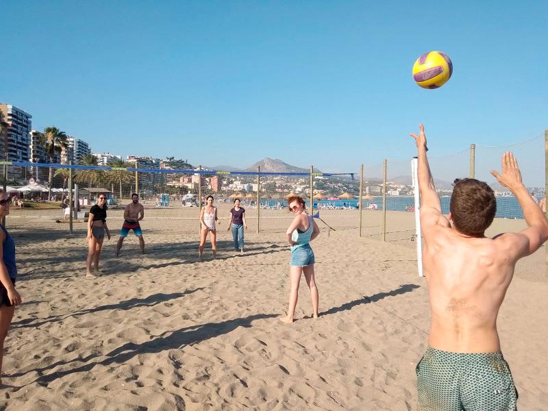 Deelnemers van een taalcursus Spaans in Spanje 1 week spelen volleybal met elkaar op het strand
