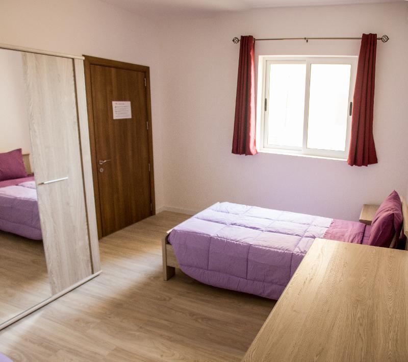 Slaapkamer met paars bed tijdens taalreis Malta