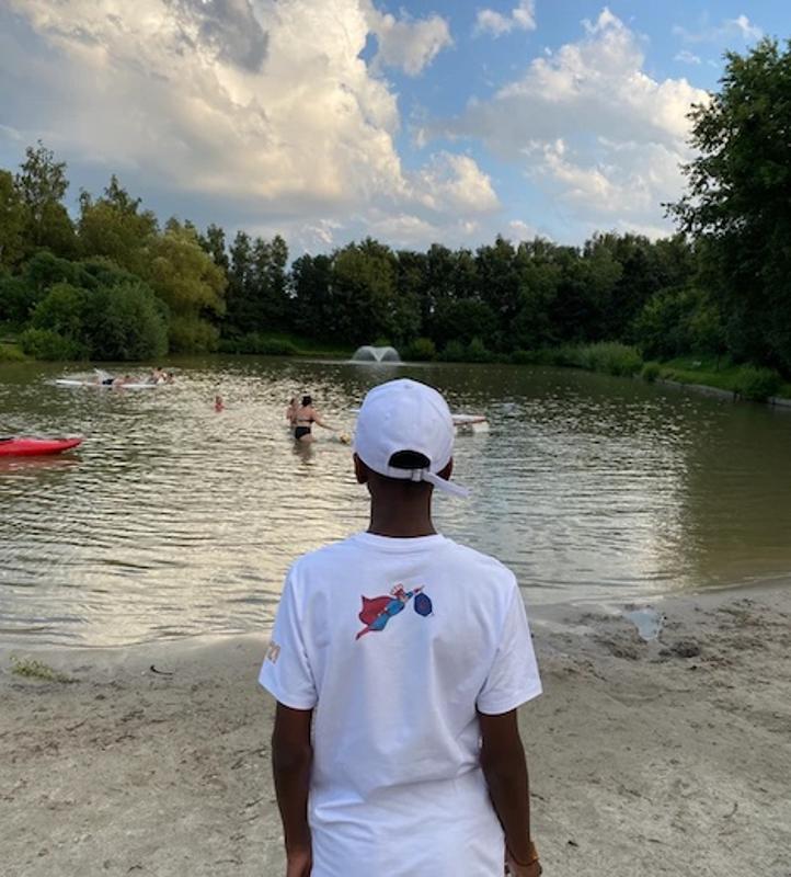 enfant au bord de l'eau d'un lac en camp de vacances