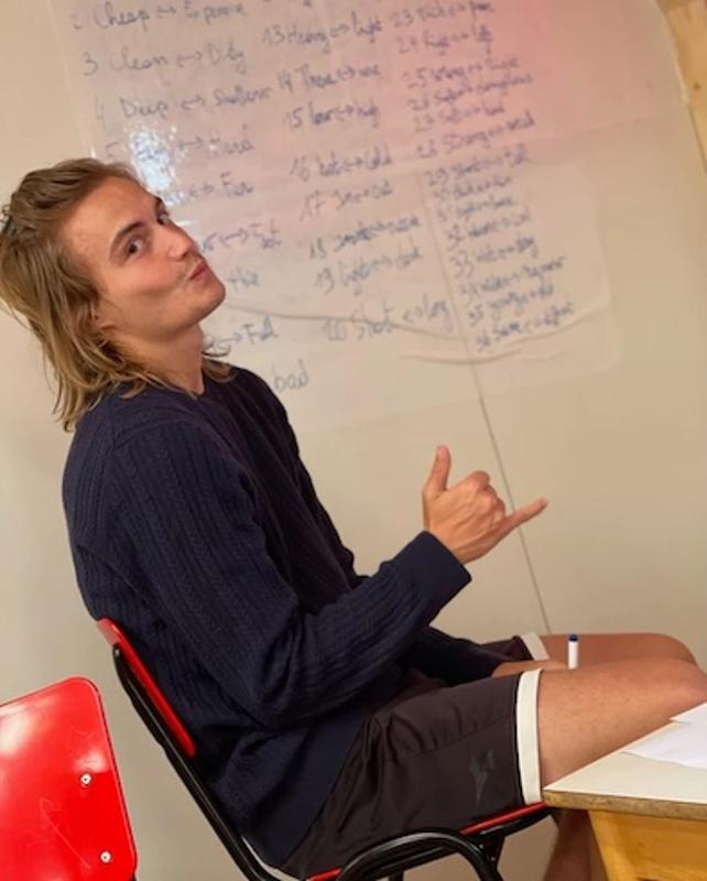 jeune qui fait un signe à la caméra assis en stage langue angleterre