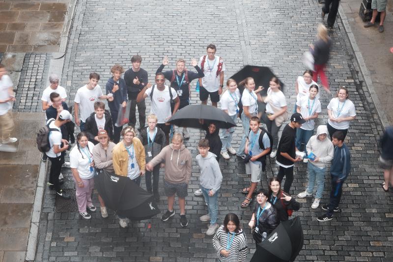 Een groepsfoto van bovenaf terwijl het regent met een Engels kamp in Engeland
