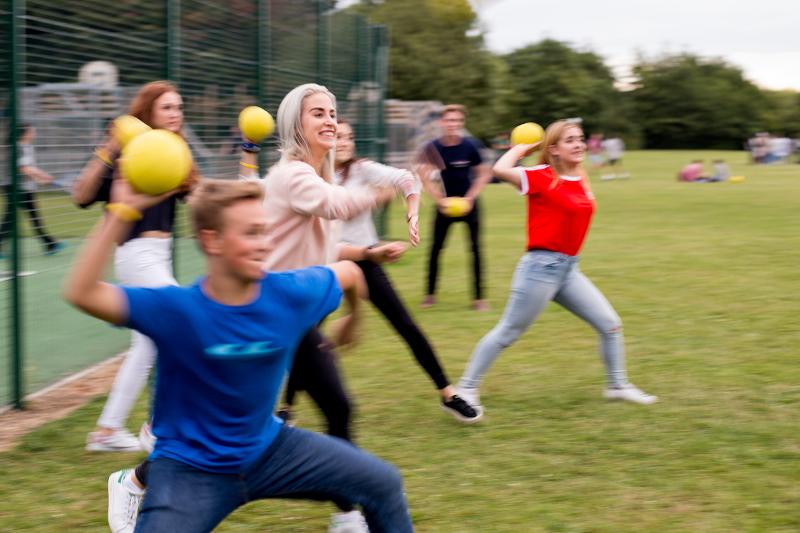 Kinderen gooien gele ballen tijdens de taalcursussen buitenland