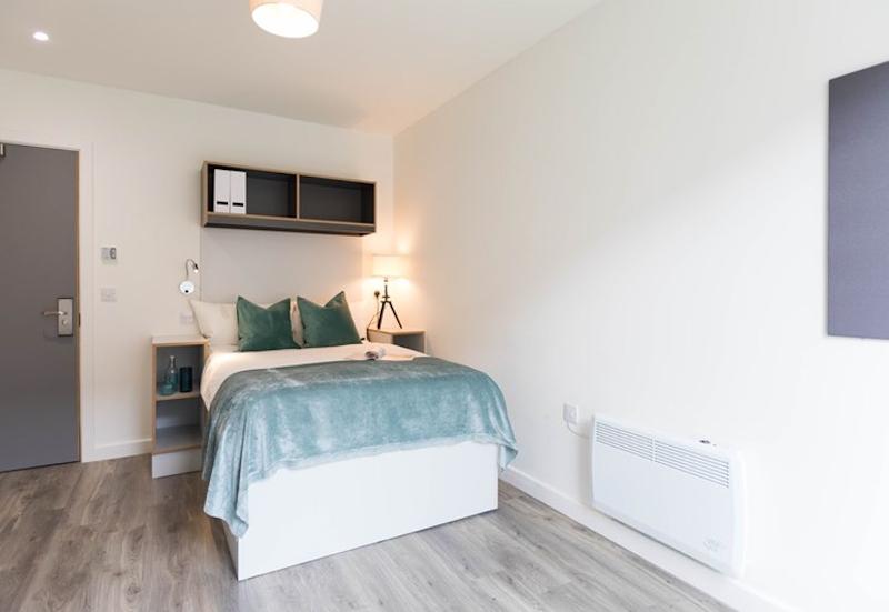 Bed in residentie met blauw beddengoed tijdens de taalcursussen buitenland