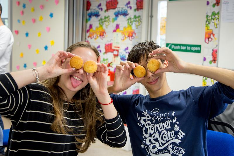 Kinderen houden muffins voor ogen tijden de taalcursussen buitenland