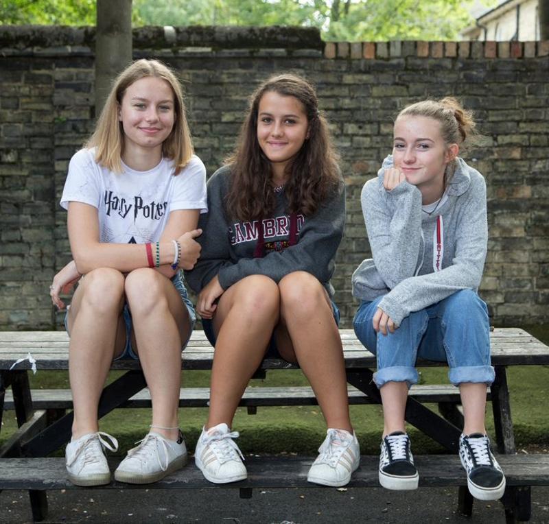 Meisjes zitten samen op picknicktafel tijdens de taalcursussen buitenland