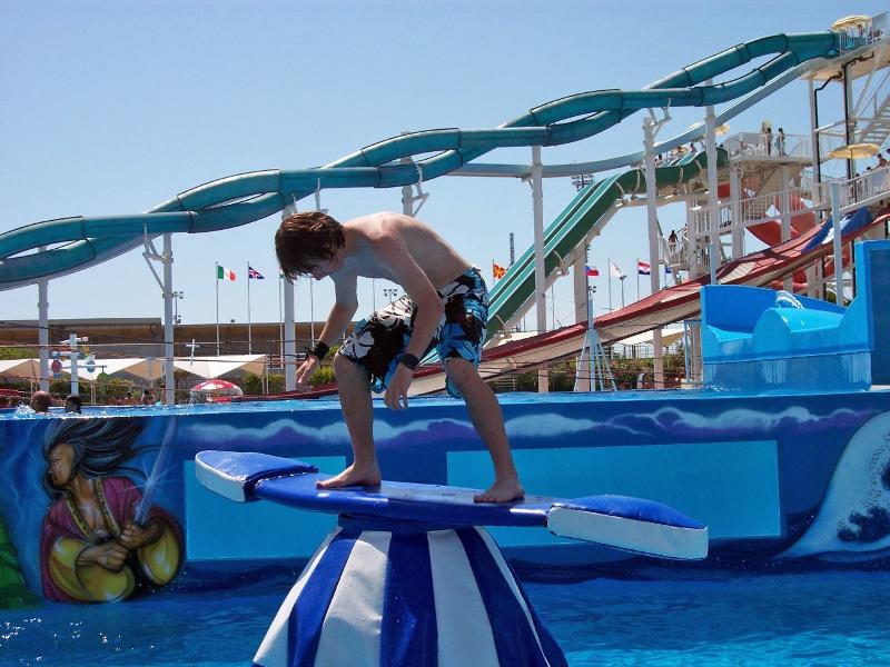 Jongen op surfplank in aquapark tijdens taalreis Italië