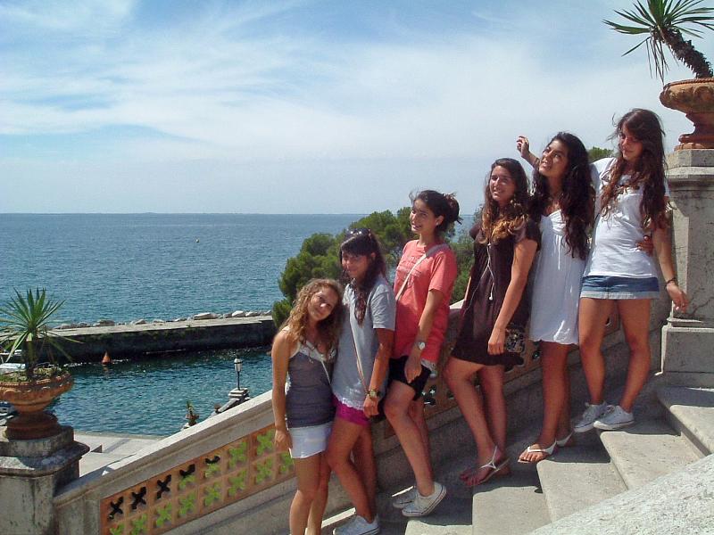 Groepsfoto op trap aan het strand tijdens de taalreis Italië