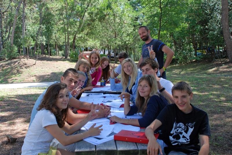Deelnemers krijgen les aan picknicktafel tijdens taalreis Italië