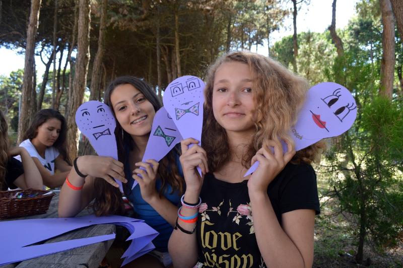 Meiden met geknutselde smileys tijdens de taalreis Italië