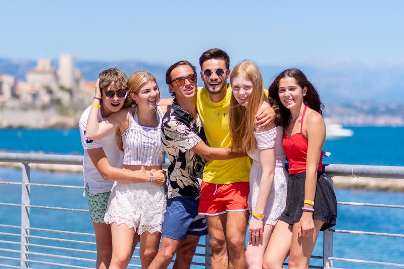 Deelnemers van groepsreis April poseren samen voor de foto met een uitzicht op de zee
