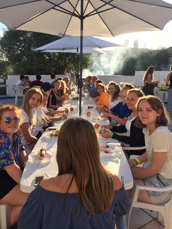Deelnemers eten samen barbecue buiten tijdens de taalreis Frankrijk