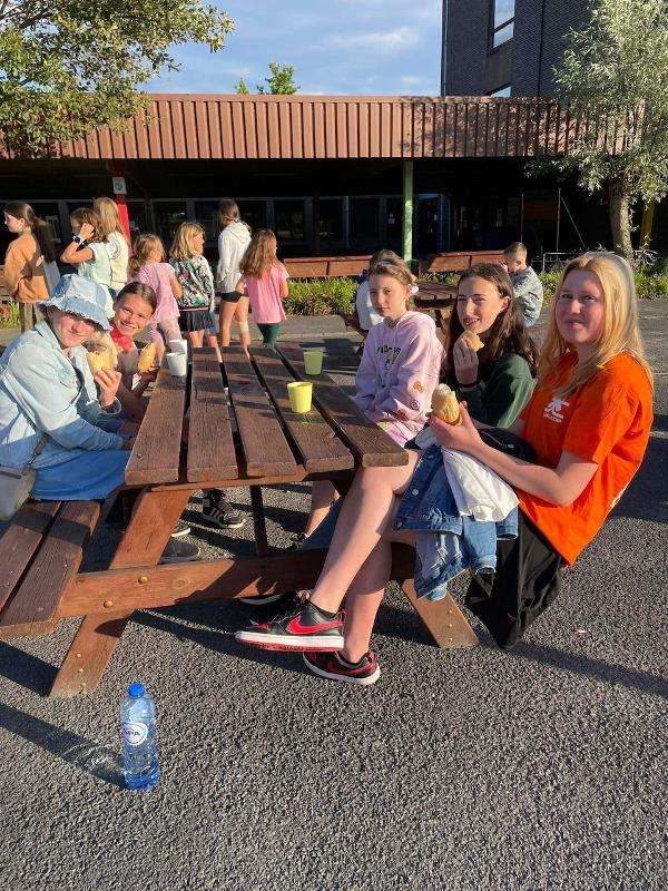 Meisjes lunchen buiten tijdens meidenkamp