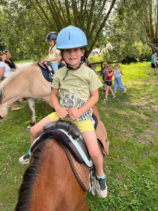 Jongen op een paard met paardrijden kamp