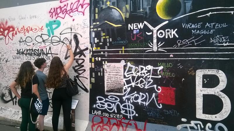 Leerlingen tekenen op Berlijnse muur tijden taalreis Duitsland