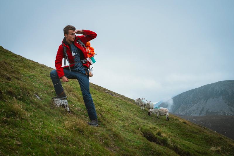 Een deelnemer van jongerenreis 17 jaar poseert avontuurlijk op de berg