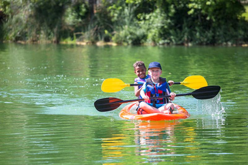 enfants sur un canoe qui rame en colonie de vacances juillet
