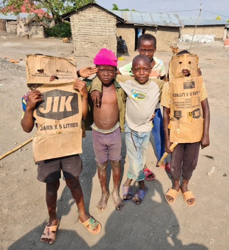 Kinderen zijn aan het spelen met karton tijdens de groepsreis Afrika.