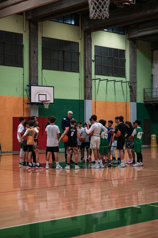 Jongens krijgen uitleg op een internationaal kamp Groep jongeren krijgt uitleg tijdens basketbalkamp