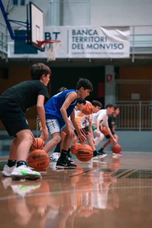 Jongeren spelen basketbal op een internationaal kamp Jongens zijn aan het basketballen op een basketbalkamp