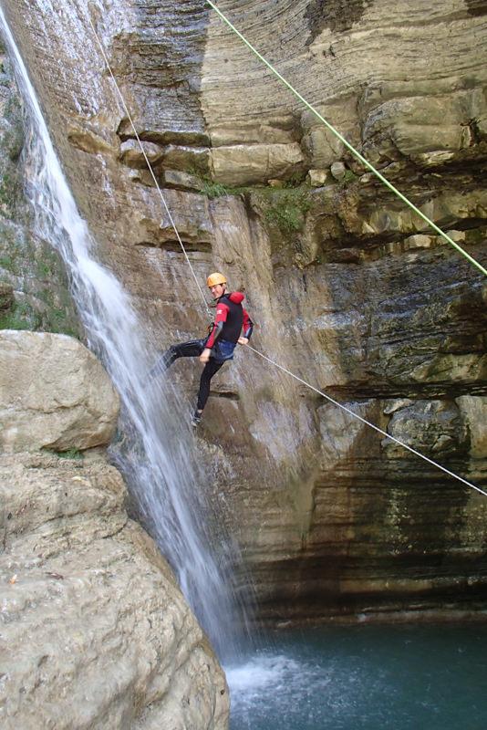 Een jongen daalt af van een waterval tijdens een groepsreis in juni.