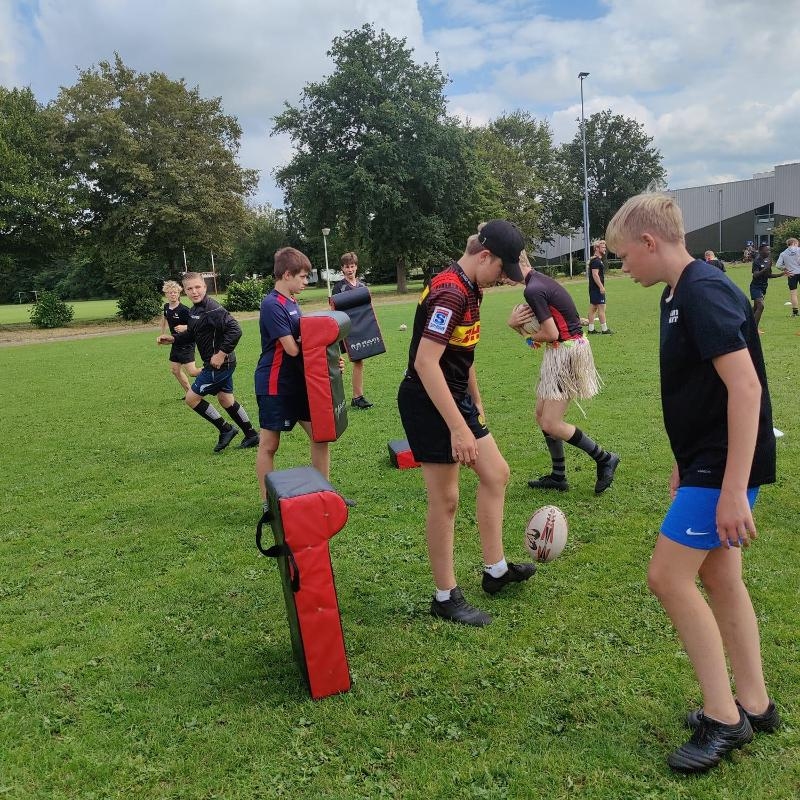 Deelnemers zijn aan het trainen tijdens de Rugbykampen