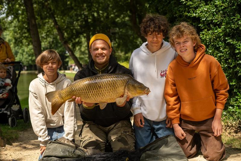 Vang bizar grote vissen tijdens een viskamp Lommel Jongens en begeleider poseren voor groepsfoto met grote vis