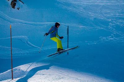 Meisje springt met haar ski's op skikamp