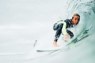 Jongen die aan het surfen is tijdens een surfvakantie 