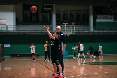 Jongen is aan het leren basketballen tijdens basketbalkamp