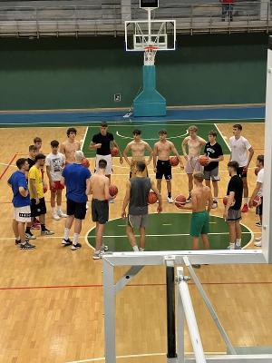 Groep jongens krijgt uitleg op een basketbalkamp